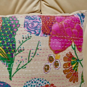 Puede incluir: Una funda de coj&iacute;n de algod&oacute;n beige con un patr&oacute;n floral. El patr&oacute;n presenta flores y hojas rosas, verdes, amarillas, naranjas y azules. La funda de coj&iacute;n est&aacute; decorada con costuras blancas.