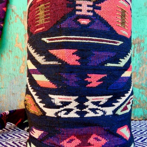 May include: A black and red patterned pillow with geometric designs. The pillow is made of a woven fabric with a textured surface.