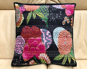 Könnte beinhalten: Schwarzer Baumwoll-Kissenbezug mit einem floralen Muster in den Farben Rosa, Orange, Grün und Weiß. Der Kissenbezug ist gesteppt und hat einen schwarzen Rand.