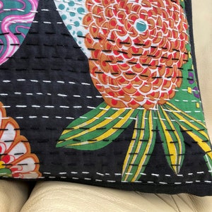 May include: Black cotton pillow cover with a floral pattern in shades of pink, red, green, yellow, and white. The pillow cover is quilted with white thread and has a black border.