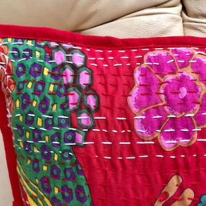 K&ouml;nnte beinhalten: Roter Baumwoll-Kissenbezug mit floralem und geometrischem Muster. Der Kissenbezug ist handgen&auml;ht mit wei&szlig;em Garn und hat einen roten Rand.