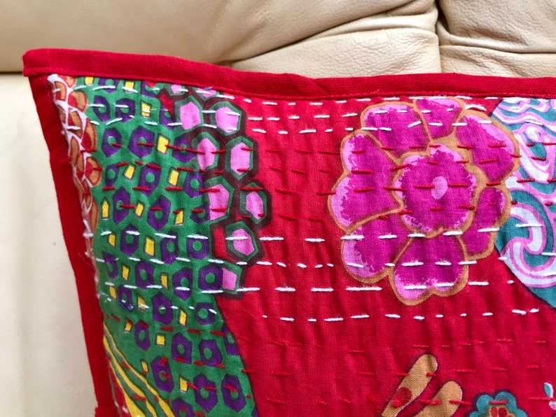 K&ouml;nnte beinhalten: Roter Baumwoll-Kissenbezug mit floralem und geometrischem Muster. Der Kissenbezug ist handgen&auml;ht mit wei&szlig;em Garn und hat einen roten Rand.