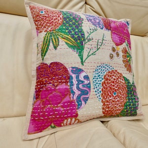 Puede incluir: Una funda de coj&iacute;n de color crema con un patr&oacute;n floral en tonos de rosa, naranja, verde y azul. El patr&oacute;n presenta flores grandes, hojas y remolinos. La funda de coj&iacute;n est&aacute; hecha de algod&oacute;n y tiene una textura acolchada sutil.