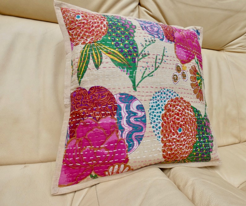 Puede incluir: Una funda de coj&iacute;n de color crema con un patr&oacute;n floral en tonos de rosa, naranja, verde y azul. El patr&oacute;n presenta flores grandes, hojas y remolinos. La funda de coj&iacute;n est&aacute; hecha de algod&oacute;n y tiene una textura acolchada sutil.