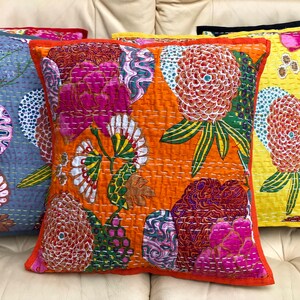 K&ouml;nnte beinhalten: F&uuml;nf bunte Kissen mit Blumenmustern. Die Kissen sind auf einem wei&szlig;en Sofa angeordnet. Die Kissen sind aus einem weichen, gesteppten Stoff gefertigt. Die Kissen sind in verschiedenen Farben, darunter Rot, Blau, Orange, Gelb und Schwarz.
