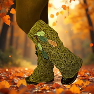 Puede incluir: Calentadores de piernas de ganchillo verde con detalles de hojas. Los calentadores de piernas están decorados con hojas verdes y marrones. La persona camina sobre un lecho de hojas naranjas.