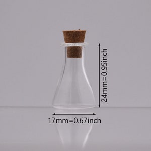 May include: A clear glass bottle with a cork stopper. The bottle is 2.4 inches tall and 0.67 inches wide.