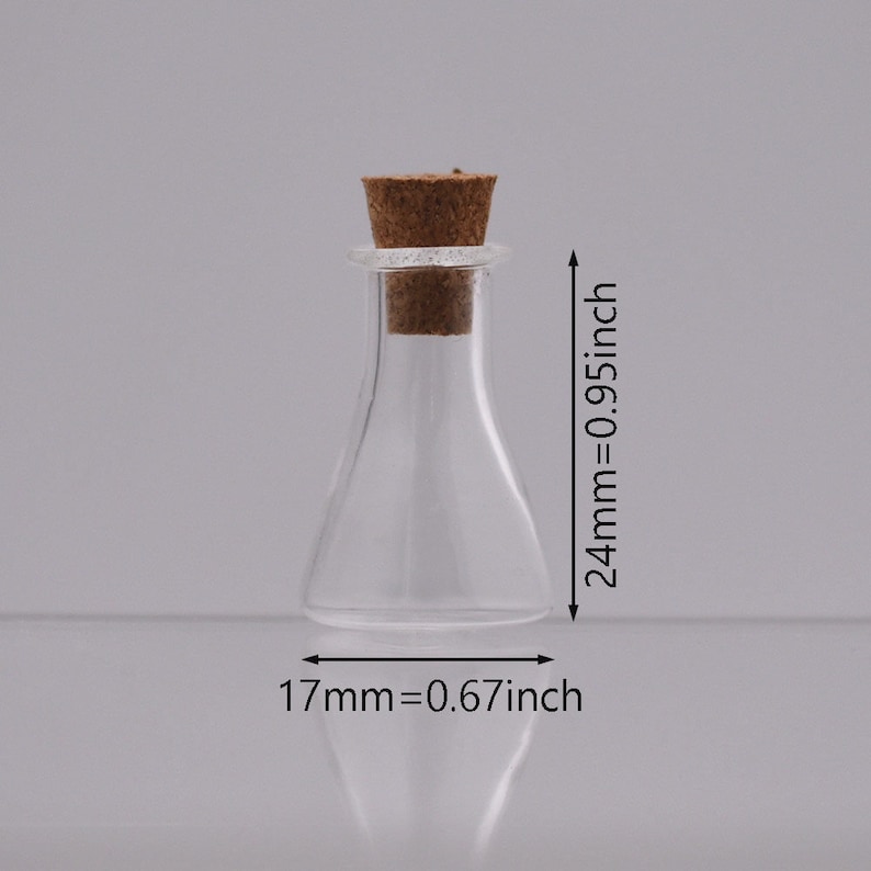 May include: A clear glass bottle with a cork stopper. The bottle is 2.4 inches tall and 0.67 inches wide.
