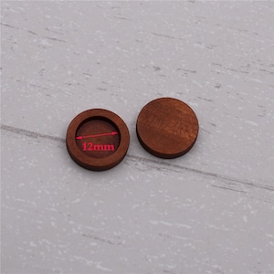 May include: Two round wooden blanks, one with a recessed center. The blank with the recessed center measures 12mm in diameter.