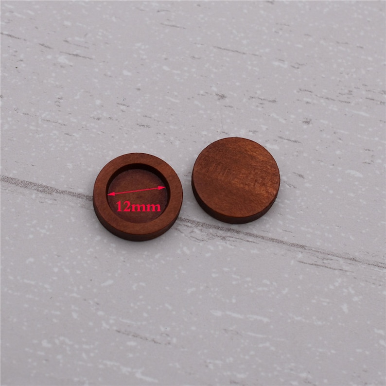 May include: Two round wooden blanks, one with a recessed center. The blank with the recessed center measures 12mm in diameter.