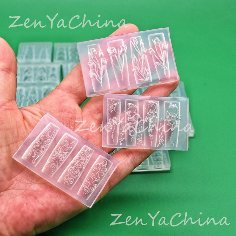 May include: Clear silicone molds with floral and ornamental designs. The molds feature rectangular compartments with detailed embossed patterns of tulips, flowers, and decorative scrollwork. The text "Zen Ya China" is visible.