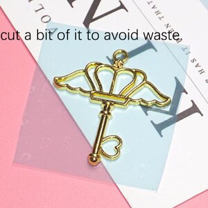 May include: Gold-toned metal key charm with a crown and wings. The key has a heart-shaped hole at the bottom. You can cut a bit of it to avoid waste. AND EVER HAS IT BEN THAT