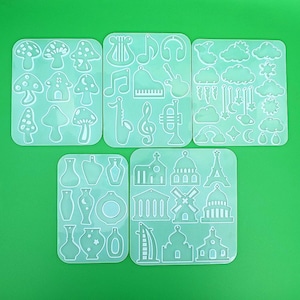 May include: Six clear silicone sheets with different shapes for making resin earrings. The shapes include mushrooms, musical notes, a harp, a microphone, a guitar, a trumpet, a key, a crown, a building, a windmill, a Eiffel Tower, and a Christmas tree.