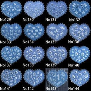 May include: A selection of heart-shaped moulds featuring diverse designs such as leaves, circles, butterflies, and marine life. Each mould is a translucent blue hue with a scalloped edge. Numbers from No129 to No144 are printed on the moulds.