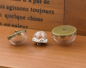 May include: Three glass dome pendant charms with antique bronze metal frames. The domes are clear and have a decorative silver trim around the top edge. The charms have a loop at the top for hanging.