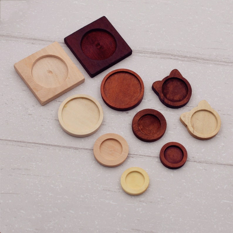 May include: Assortment of wooden round and square blank tray bases in various sizes. The bases are made of natural wood and have a smooth finish. They are perfect for crafting and creating unique jewelry pieces.