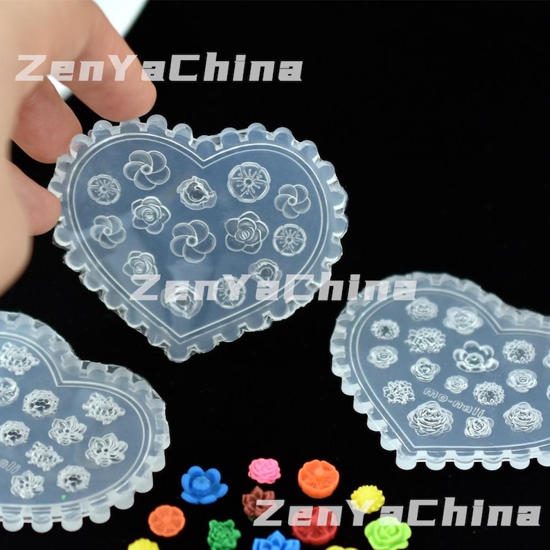 May include: Clear, heart-shaped moulds with scalloped edges, filled with various flower designs. The moulds are held by a hand, with several colourful flower-shaped embellishments at the bottom. The text "ZenYaChina" is visible.