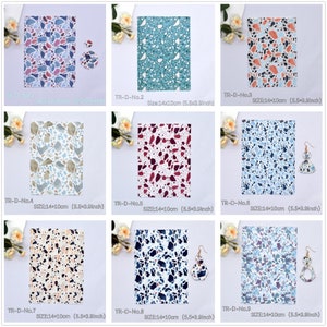 May include: Nine different patterned fabric swatches with a terrazzo design. Each swatch measures 14 by 10 cm. Some swatches have matching earrings with a terrazzo design.