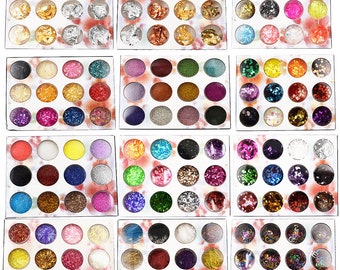 May include: A set of 72 small jars filled with various glitter and iridescent flakes. The jars are arranged in a grid pattern on a white background.
