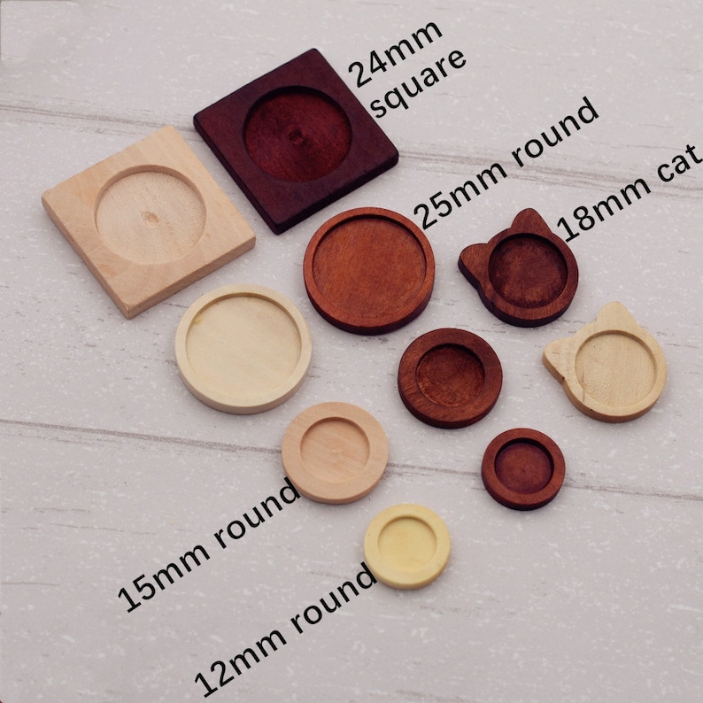 May include: Assortment of wooden round and square blank tray bases in various sizes, including 12mm, 15mm, 18mm, 24mm, and 25mm. The bases are made of natural wood and have a smooth finish.