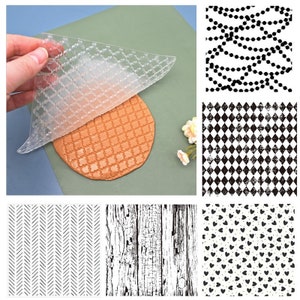 May include: A set of 10 clear silicone stamps with various patterns, including a checkered pattern, a wood grain pattern, a herringbone pattern, a heart pattern, and a chain pattern. The stamps are shown on a green surface.