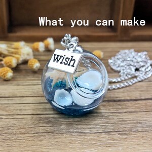 May include: A silver necklace with a glass orb pendant containing seashells and blue glitter. The orb has a silver charm attached that says "wish".