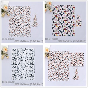 May include: Four sheets of patterned fabric with different terrazzo designs. Each sheet measures 14 by 10 cm. The fabric is white with various coloured flecks and shapes.