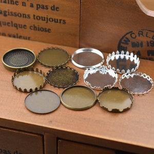 Puede incluir: Surtido de engastes redondos de metal para la elaboración de joyas. Los engastes son de varios tamaños y estilos, incluyendo algunos con un borde decorativo. Algunos son plateados y otros son de bronce.