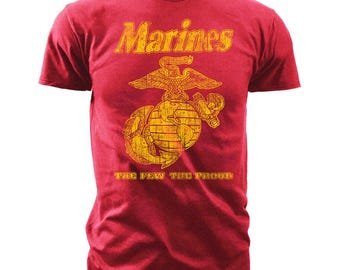 Könnte beinhalten: Rotes T-Shirt mit einer gelben Vintage-Grafik des US Marine Corps-Emblems, einschließlich der Worte "Marines", "The Few, The Proud" und einem Globus mit einem Adler darüber.