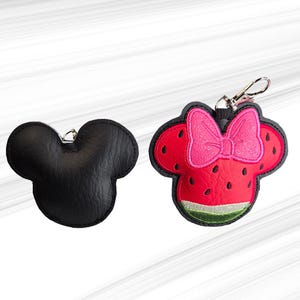 K&ouml;nnte beinhalten: Zwei Schl&uuml;sselanh&auml;nger in Form eines M&auml;usekopfes. Einer ist einfarbig schwarz, der andere ist rot mit einer rosa Schleife und Wassermelonen-Design. Beide haben silberfarbene Verschl&uuml;sse zum Befestigen an Schl&uuml;sseln oder Taschen.