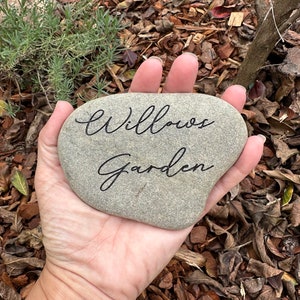 Pu&ograve; includere: Una pietra grigia con le parole "Willows Garden" incise in inchiostro nero.