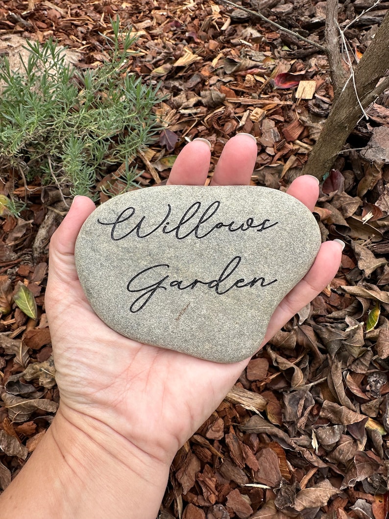 Pu&ograve; includere: Una pietra grigia con le parole "Willows Garden" incise in inchiostro nero.