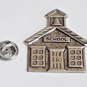 May include: Silver schoolhouse pin with a bell on top and the word "SCHOOL" on the front.
