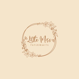 Może przedstawiać: Brązowy rysunek liniowy wieńca kwiatowego z tekstem "Little Miss Paperwhite" wewnątrz wieńca.