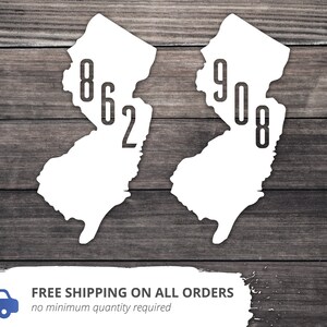 May include: Two white outlines of the state of New Jersey with the area codes 862 and 908 printed inside.