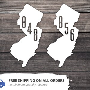 May include: Two white outlines of the state of New Jersey with the area codes 848 and 856 printed inside each outline.