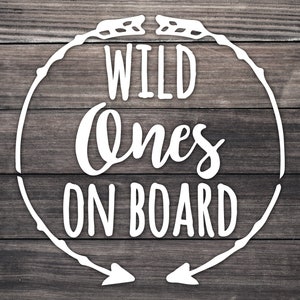 May include: White wooden sign with a circle and arrows pointing in opposite directions. The text inside the circle reads "WILD ones ON BOARD".