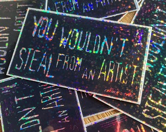 Könnte beinhalten: Ein holografischer Aufkleber mit dem Text "You wouldn't steal from an artist" in weißen Buchstaben auf schwarzem Hintergrund.