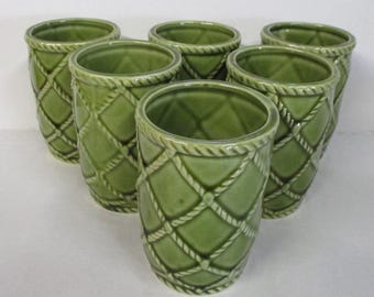 May include: Set of six green ceramic tumblers. Each tumbler features a diamond pattern created by a rope-like design. The rims of the tumblers are also trimmed with a rope design. The tumblers are a solid green color.