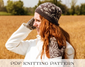 Könnte beinhalten: Eine Frau trägt einen weißen Mantel und eine braune und weiße gestrickte Mütze mit passenden Handschuhen. Die Mütze hat ein einzigartiges Design mit einem Blumenmuster. Die Frau steht auf einem Feld mit goldenem Weizen.