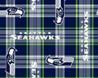 Puede incluir: Tela de los Seahawks con un patrón de cuadros azules, verdes y blancos. El logotipo de los Seahawks y el texto "Seattle Seahawks" se repiten en toda la tela.