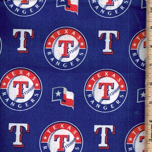 Może przedstawiać: Niebieska tkanina z powtarzającym się wzorem logo drużyny baseballowej Texas Rangers, literą "T" i flagą stanu Teksas. Loga są czerwone, białe i niebieskie, z nazwą drużyny i wzorem baseballu.