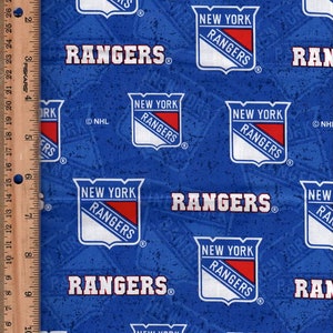 Może przedstawiać: Niebieski materiał z powtarzającym się wzorem logo drużyny hokejowej New York Rangers. Logo jest białe, czerwone i niebieskie z napisem "New York Rangers" wewnątrz tarczy. Materiał ma również napis "Rangers" nadrukowany na biało.