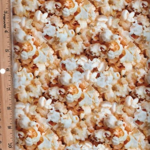 Puede incluir: Una imagen de primer plano de una gran pila de palomitas de maíz. Las palomitas de maíz son una mezcla de granos blancos y amarillos.