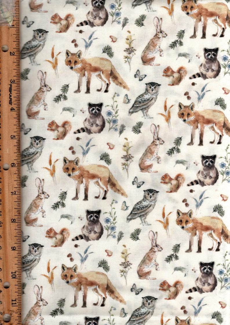 May include: A white fabric with a repeating pattern of woodland animals, including foxes, owls, raccoons, squirrels, and rabbits. The animals are illustrated in a watercolor style with brown, gray, and white tones.