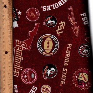 May include: Maroon fabric with repeating Florida State University logos and text. The design includes football helmets, the Seminoles logo, the state of Florida outline, and the text "FSU" and "FLORIDA STATE". A ruler is on the left side.