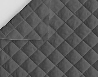 May include: A dark gray fabric featuring a quilted diamond pattern. The material has a consistent stitched texture across the surface, with a folded corner revealing a lighter gray underside, showcasing the layered construction of the textile.