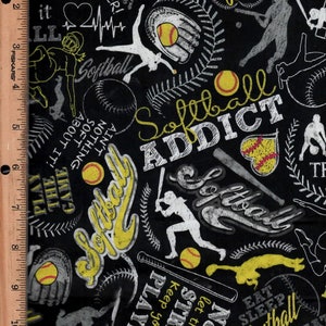 May include: Black and white fabric with a repeating pattern of yellow softball-themed illustrations. The fabric features the words "Softball Addict", "Eat Sleep Softball Repeat", "Never let the fear of striking keep you from playing the game", and "Ain't nothing soft about it".