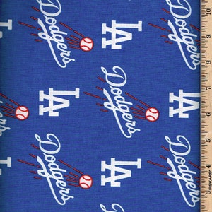 May include: Blue fabric with a repeating pattern of white "Dodgers" text with red baseballs and white "LA" text. A ruler is visible on the right side of the image.