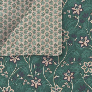 Pode incluir: Um tecido acolchoado com dois padrões distintos. Uma secção apresenta um motivo repetitivo de pequenas folhas verde-azuladas sobre um fundo bege claro, enquanto a outra secção exibe um design floral grande e fluido com flores rosa-pálido e folhas verde-escuras.